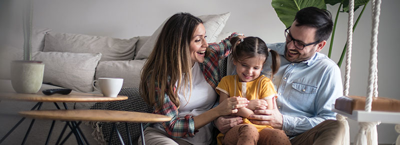 un padre y una madre abrazan a su hija