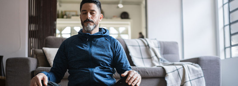 hombre meditando en el living de su casa