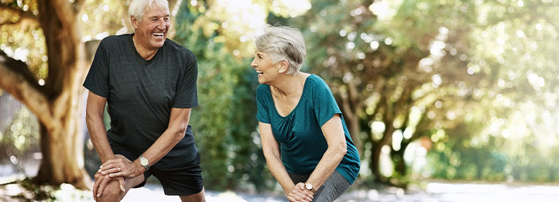 pareja de adultos mayores realizando estiramientos al aire libre