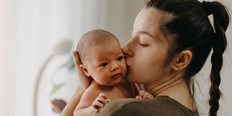 madre besando en la mejilla a su bebe