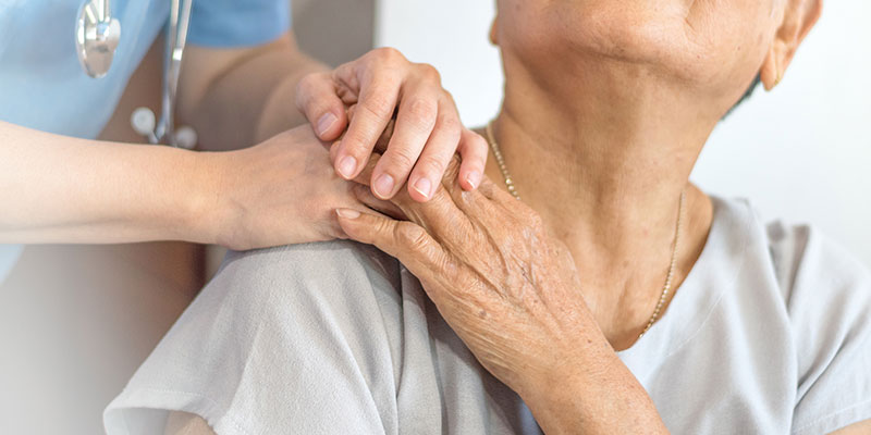 mano de una doctora descansa sobre los hombros de una paciente