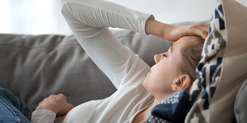 mujer recostada tomandose la cabeza