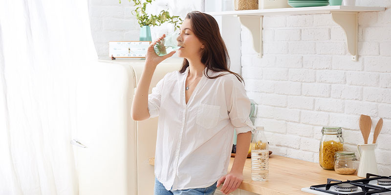 mujer bebiendo un vaso de agua