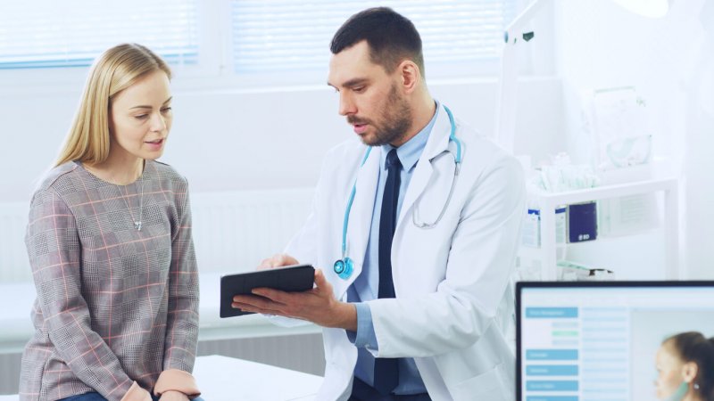 Doctor mostrando tableta digital a mujer