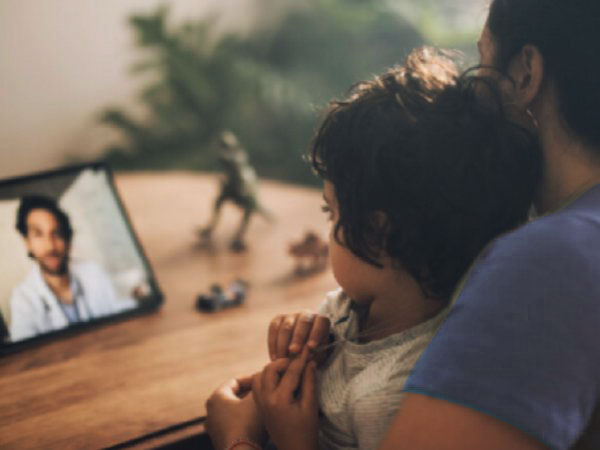 Mujer y niño en videollamada con un médico
